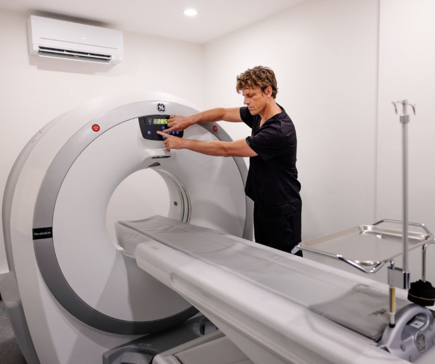 A vet operating the CT scanner console in the imaging room