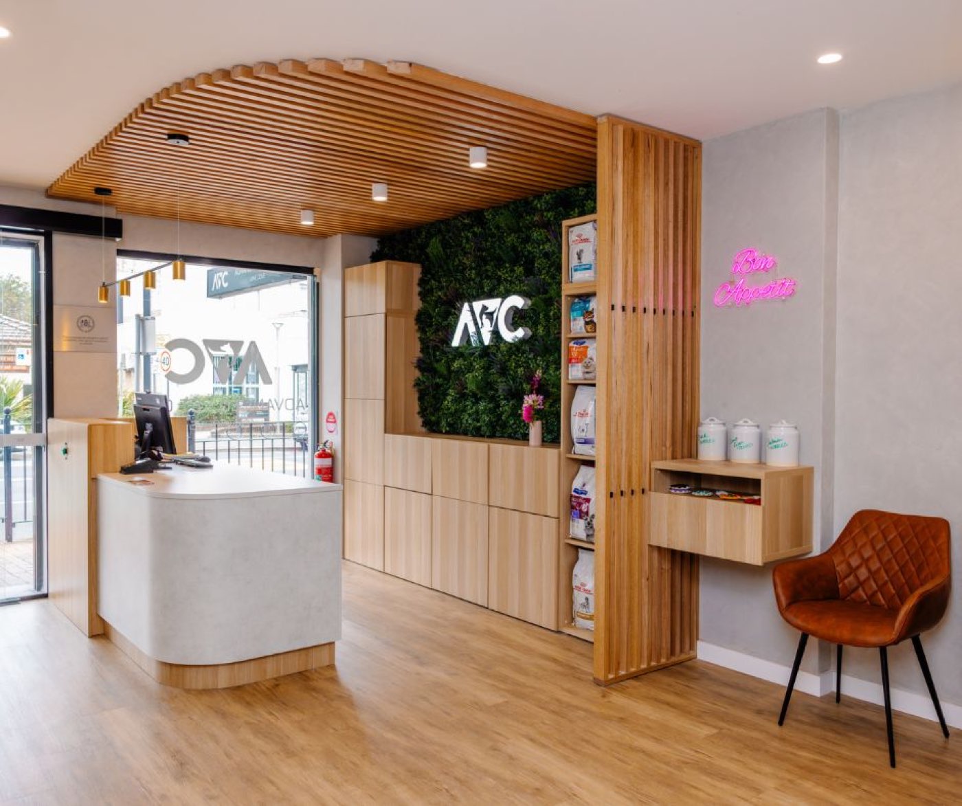 The reception counter at Advanced Vet Care Lane Cove, with a green living wall and timber slat ceiling